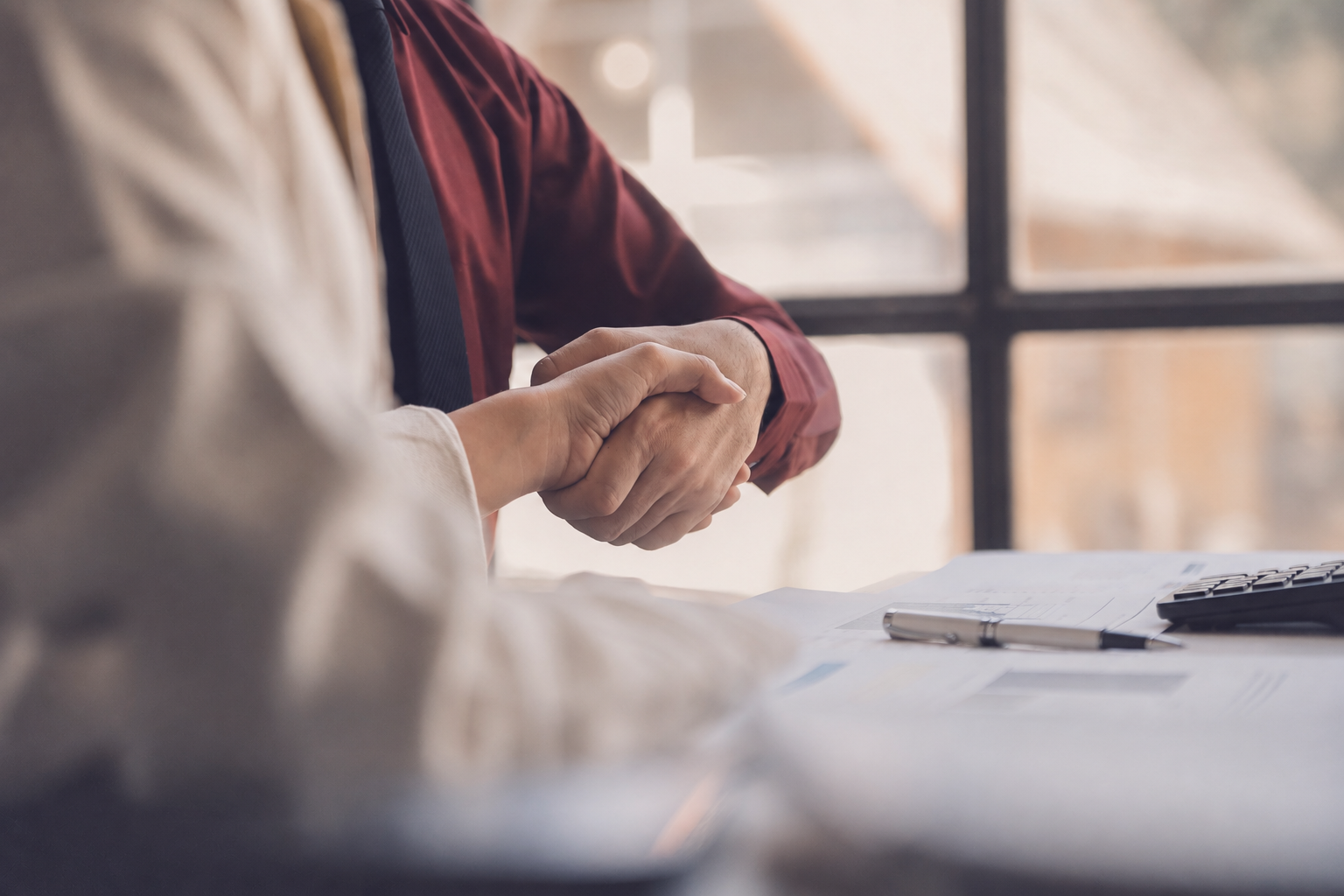 Business partners shaking hands over lending documents