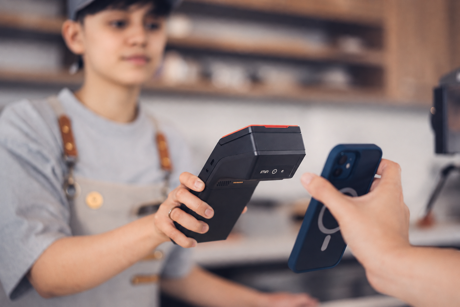 Customer making a contactless payment with a phone at a card terminal