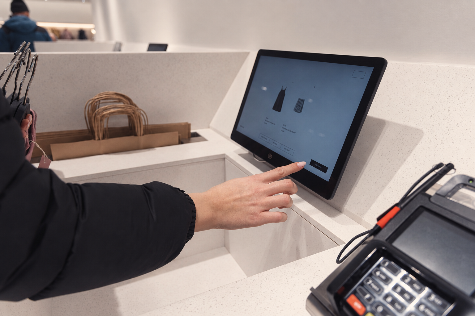 Customer using a point-of-sale touchscreen at a retail counter